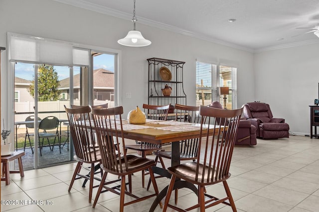 tiled dining area with ceiling fan and ornamental molding