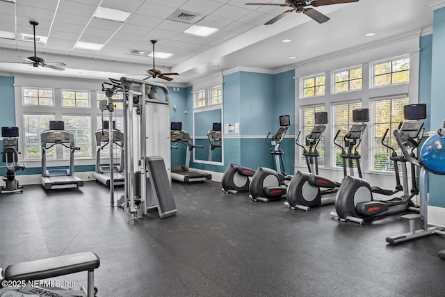 gym with ceiling fan, a drop ceiling, and a healthy amount of sunlight