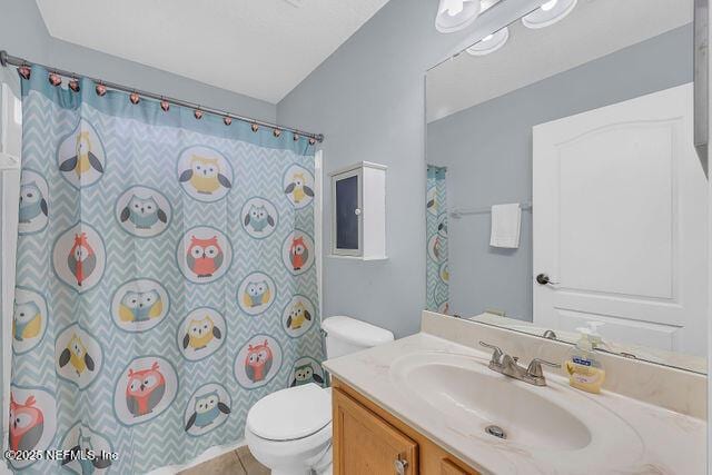 bathroom featuring vanity, curtained shower, tile patterned floors, and toilet