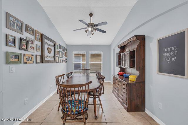 dining space featuring lofted ceiling, ceiling fan, and light tile patterned flooring