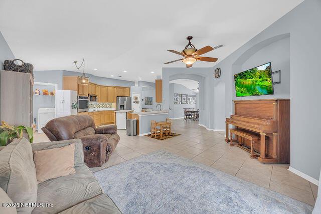 tiled living room with ceiling fan