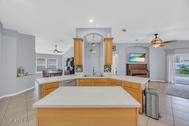 kitchen featuring light brown cabinetry, kitchen peninsula, sink, and light tile patterned floors