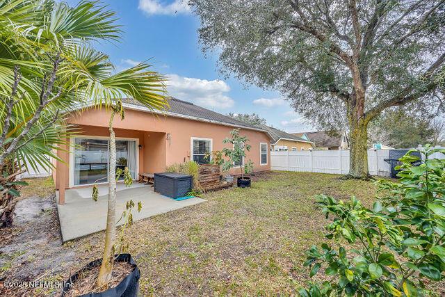 back of house with a yard and a patio