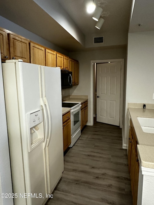 kitchen featuring sink, white appliances, and dark hardwood / wood-style flooring