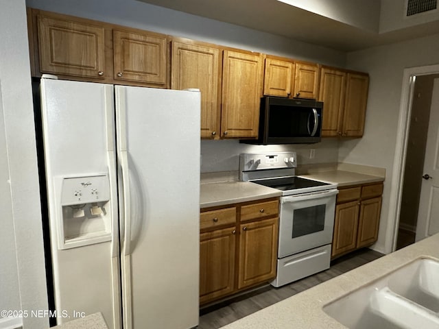 kitchen featuring sink, white appliances, and dark hardwood / wood-style floors