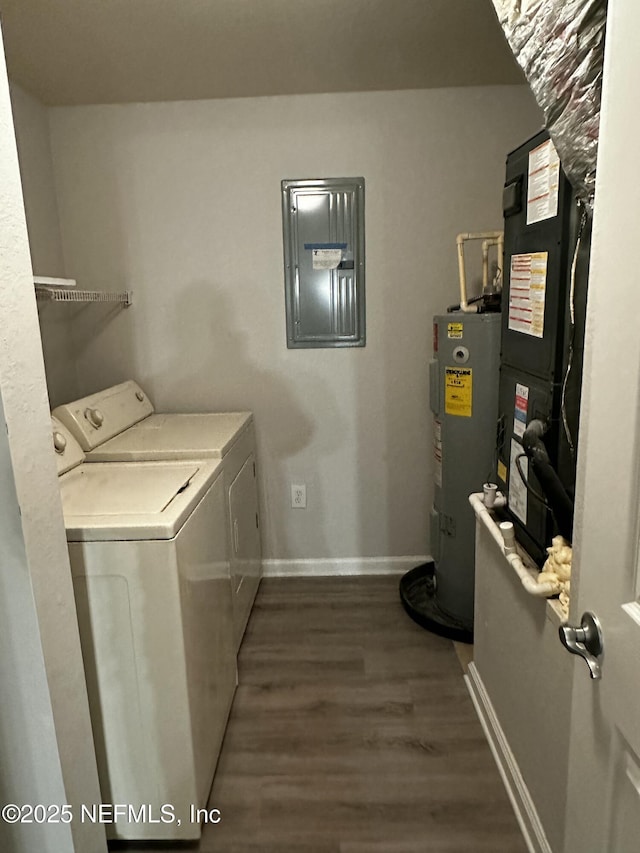 washroom featuring heating unit, washer and clothes dryer, electric panel, dark hardwood / wood-style floors, and electric water heater