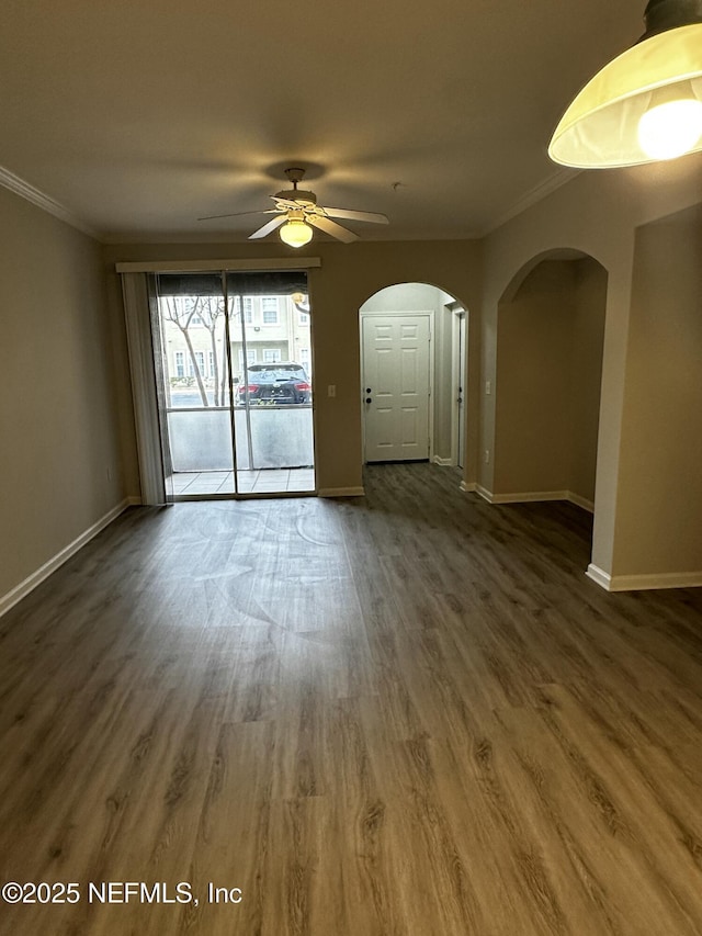 unfurnished room featuring ceiling fan, dark hardwood / wood-style flooring, and ornamental molding