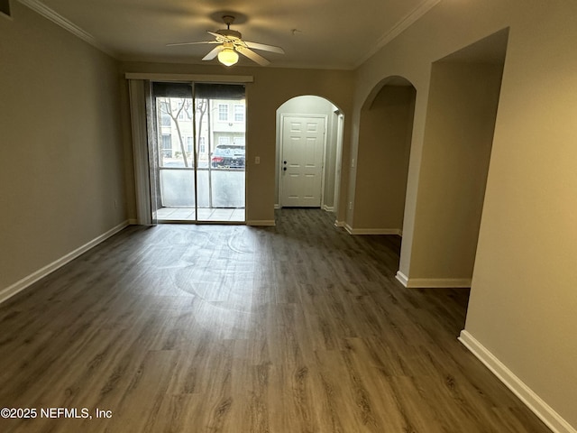 empty room with crown molding, ceiling fan, and dark hardwood / wood-style flooring