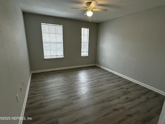 unfurnished room with ceiling fan and dark hardwood / wood-style floors