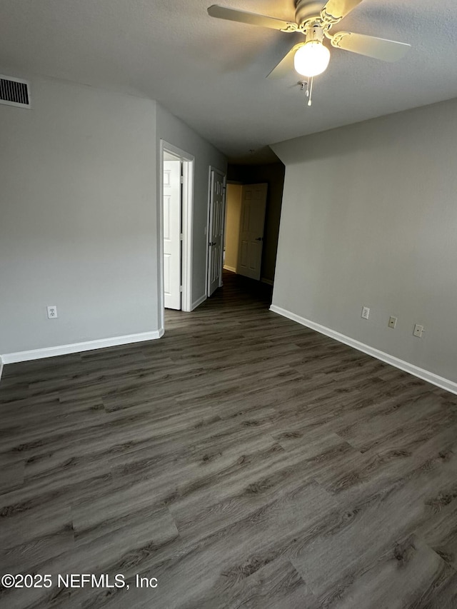 empty room with dark wood-type flooring, a textured ceiling, and ceiling fan