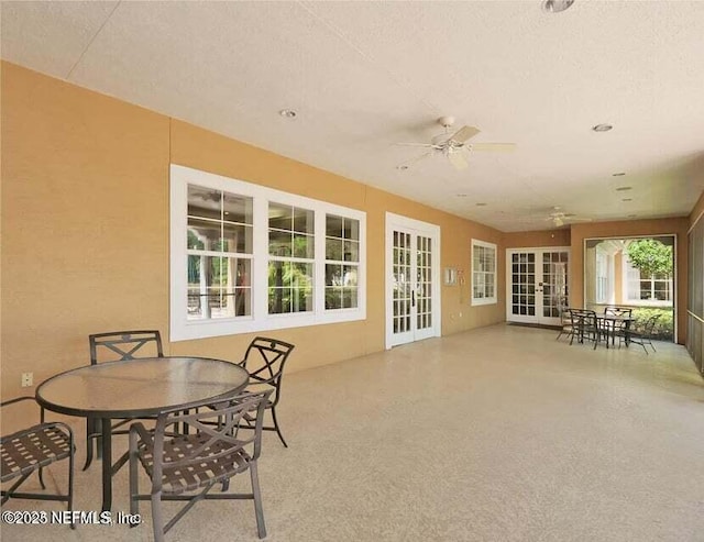 sunroom / solarium with ceiling fan and french doors