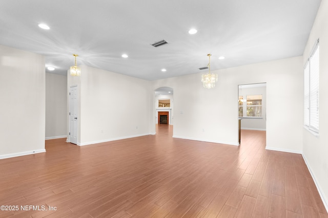 spare room featuring hardwood / wood-style flooring and an inviting chandelier