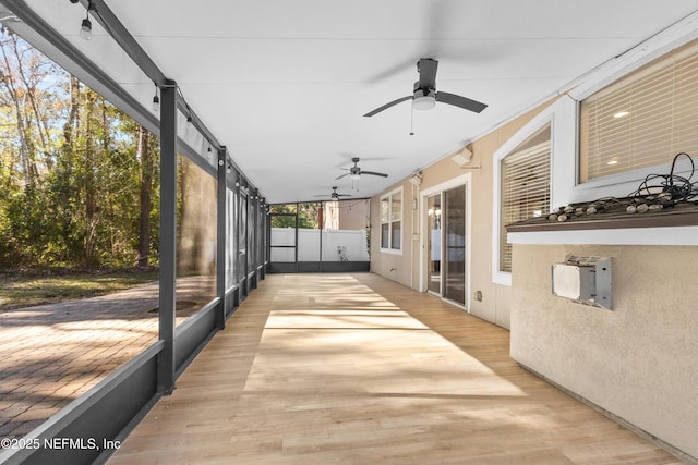 unfurnished sunroom featuring ceiling fan