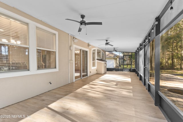 unfurnished sunroom with ceiling fan