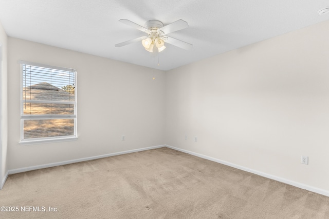 carpeted spare room with ceiling fan