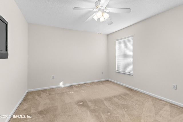 carpeted spare room with a textured ceiling and ceiling fan