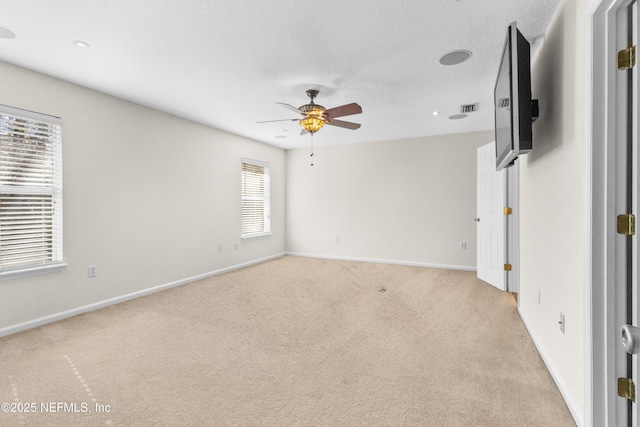 spare room featuring light carpet and ceiling fan