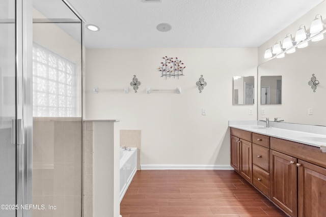 bathroom with vanity, a textured ceiling, and a washtub