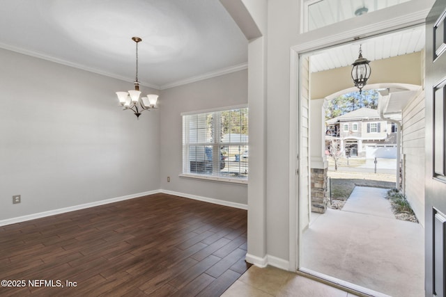 entrance foyer featuring a notable chandelier, ornamental molding, and dark hardwood / wood-style floors