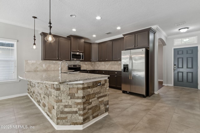 kitchen with crown molding, stainless steel appliances, dark brown cabinetry, decorative light fixtures, and kitchen peninsula