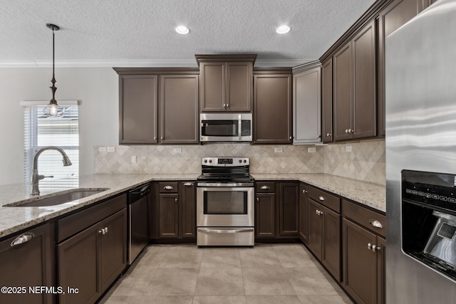 kitchen featuring sink, stainless steel appliances, light stone counters, ornamental molding, and decorative light fixtures