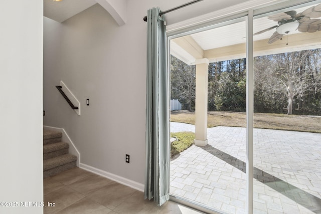 doorway with tile patterned floors and ceiling fan