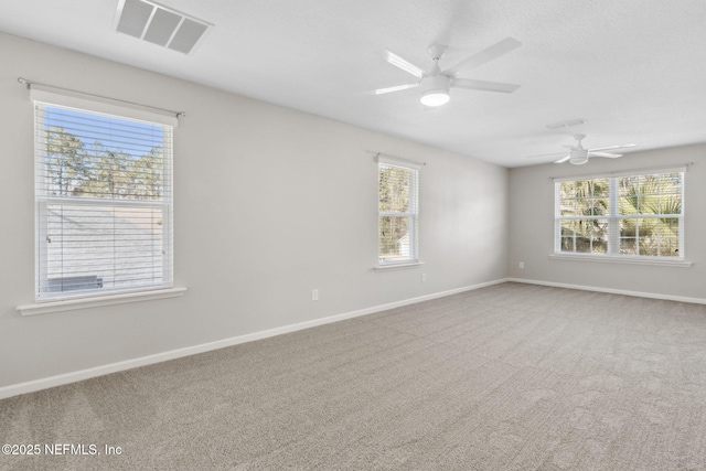 carpeted empty room featuring a healthy amount of sunlight and ceiling fan