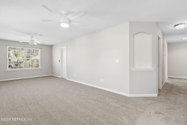 unfurnished room featuring ceiling fan, light colored carpet, and a textured ceiling