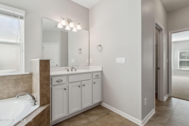 bathroom featuring vanity, tile patterned floors, and tiled bath