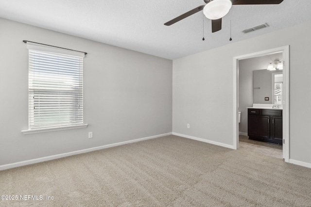 carpeted spare room with sink and ceiling fan