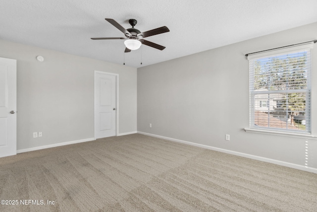 unfurnished room with ceiling fan, carpet floors, a textured ceiling, and a wealth of natural light