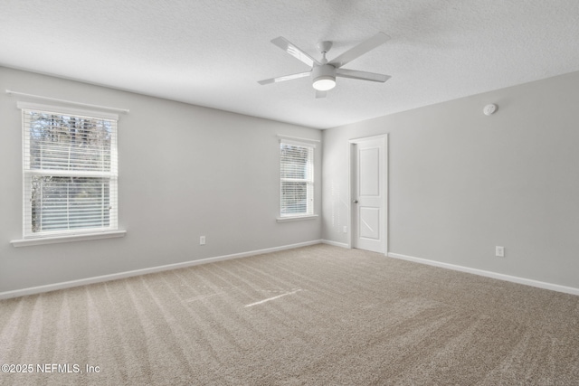 carpeted empty room with a healthy amount of sunlight, a textured ceiling, and ceiling fan