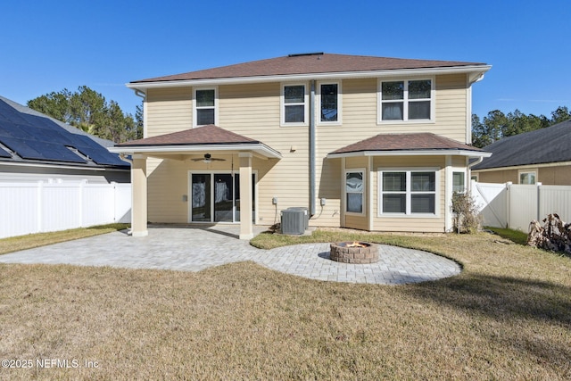 back of property with a lawn, cooling unit, ceiling fan, an outdoor fire pit, and a patio area