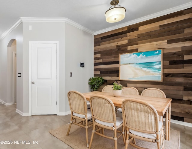 dining area with crown molding and wood walls