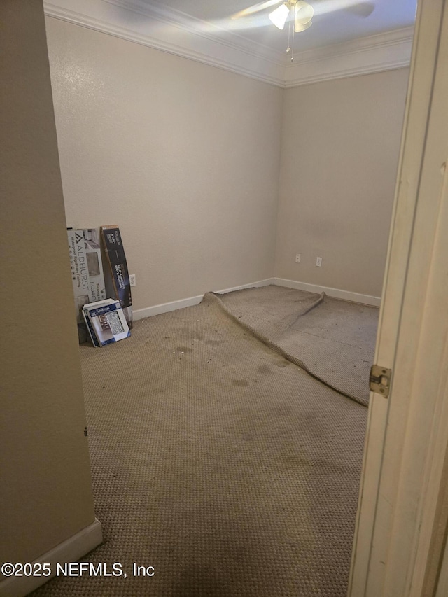 carpeted empty room featuring ceiling fan and crown molding