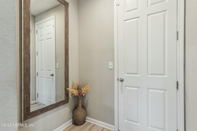 interior space featuring baseboards and light wood finished floors