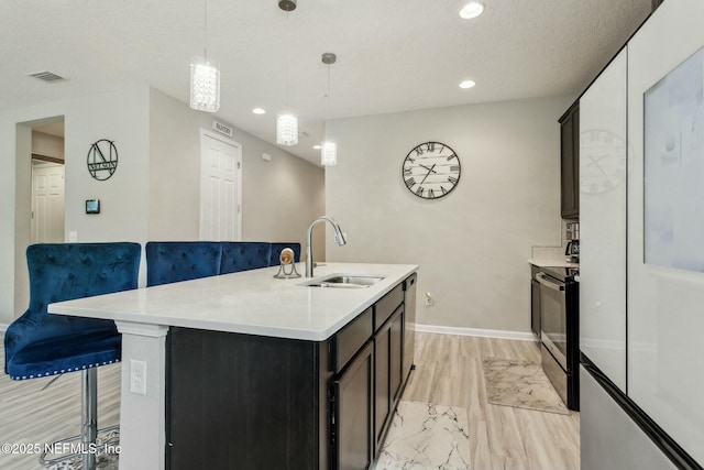 kitchen featuring stainless steel appliances, light countertops, visible vents, and a sink