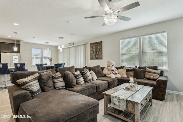 living room featuring light wood-style floors, recessed lighting, baseboards, and a ceiling fan