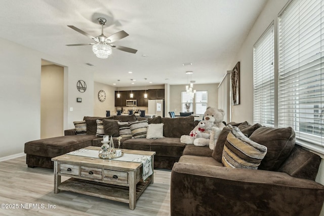 living area featuring light wood finished floors, baseboards, a ceiling fan, and recessed lighting