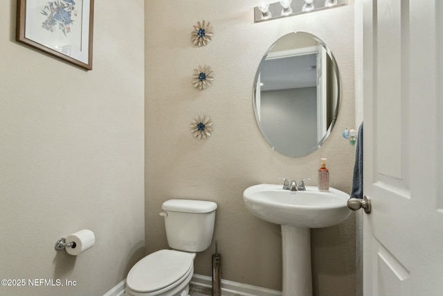 bathroom featuring toilet and baseboards