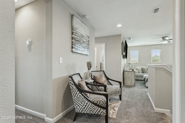 hallway featuring carpet floors, visible vents, and baseboards