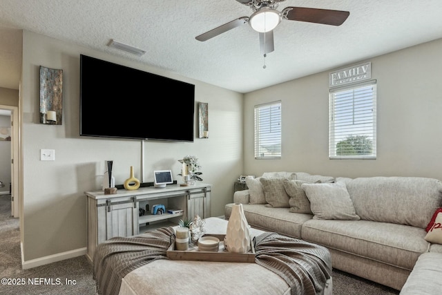 carpeted living area with a textured ceiling, a ceiling fan, visible vents, and baseboards