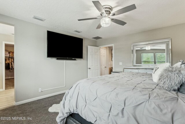 carpeted bedroom with visible vents, ceiling fan, a textured ceiling, and baseboards