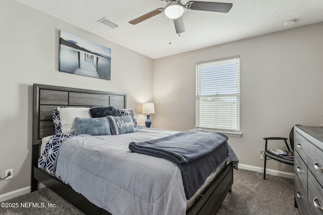 bedroom featuring baseboards, visible vents, ceiling fan, a textured ceiling, and dark carpet