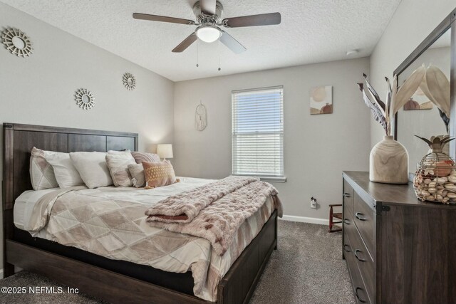 bedroom with a ceiling fan, dark carpet, a textured ceiling, and baseboards