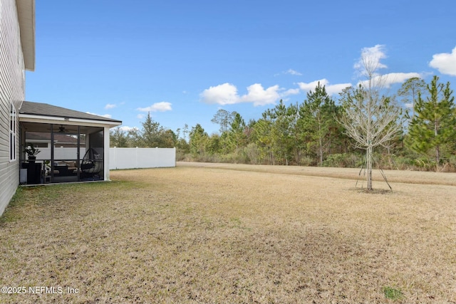 view of yard with fence and a ceiling fan