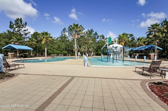 community pool with a patio area and a water play area