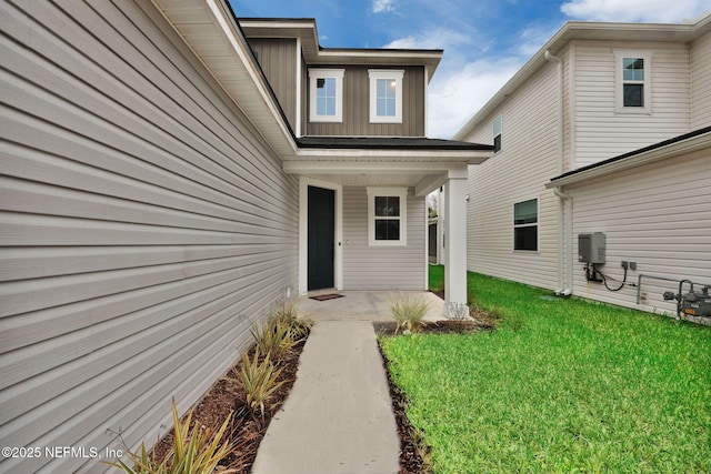 entrance to property with a lawn