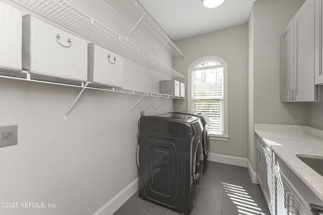 washroom with cabinets, dark tile patterned floors, and independent washer and dryer