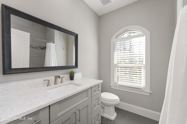 bathroom with a shower with curtain, vanity, tile patterned floors, and toilet